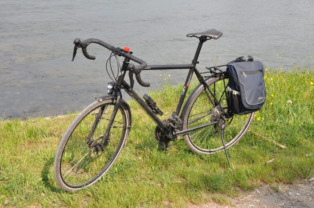 Fahrrad mit Satteltasche am Rheinufer.