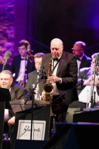 Foto Klaus mit Saxophon, umgeben von Musiker der Blue note BIG BAND